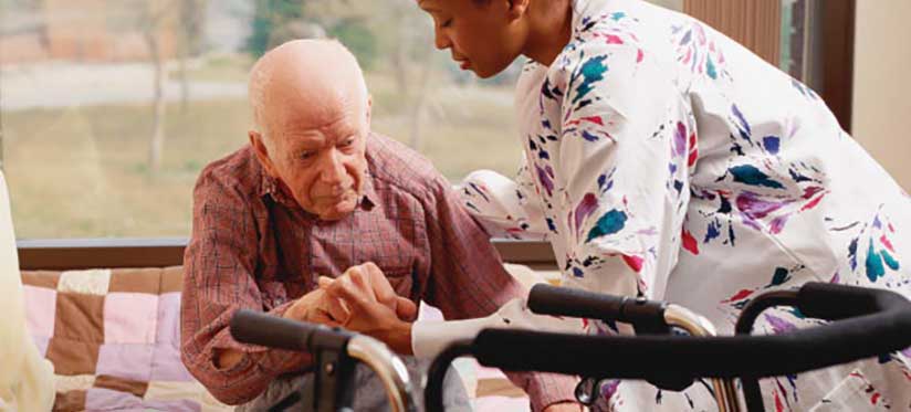 In-home nurse helping man with walker