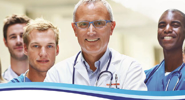 Four providers standing in hallway smiling and ready to see patients.
