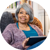 A woman sitting with an iPad in her lap.
